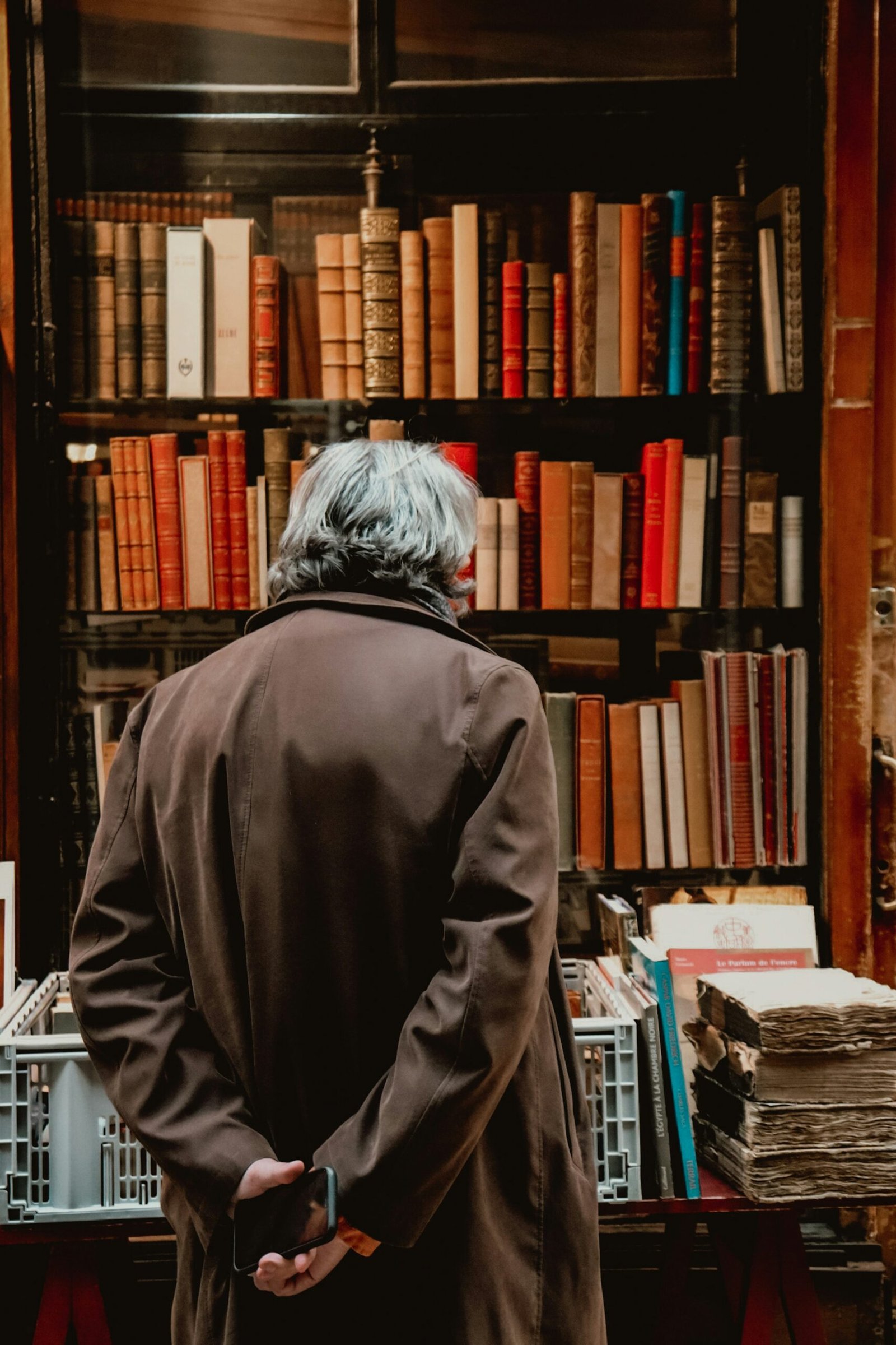person in gray hoodie standing near books
