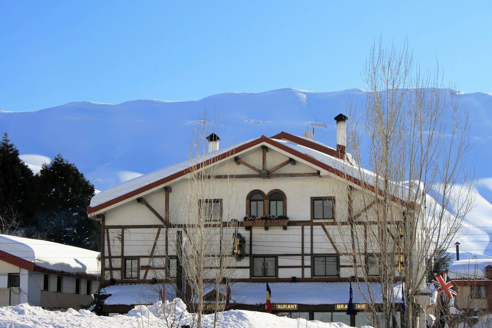 white and black concrete house near mountain during daytime